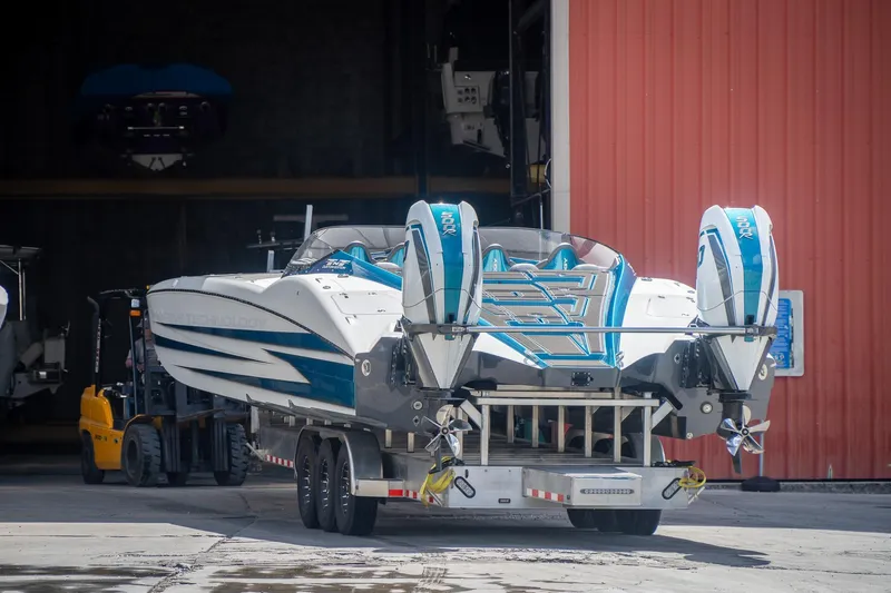  Yacht Photos Pics 2024 MTI 440X powerboat with dual engines on a trailer outside a warehouse.