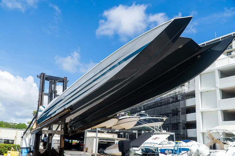  Yacht Photos Pics 2024 MTI 440X powerboat lifted in marina, clear blue sky background.