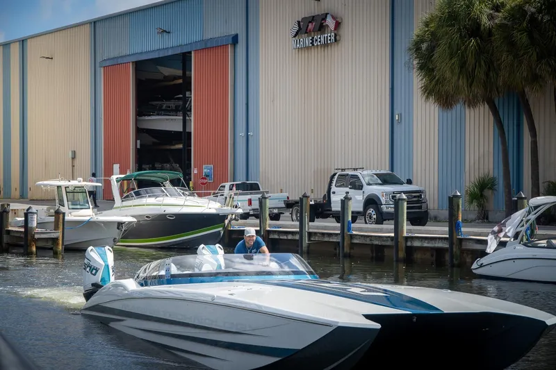  Yacht Photos Pics 2024 MTI 440X boat at marina, near marine center and parked vehicles.