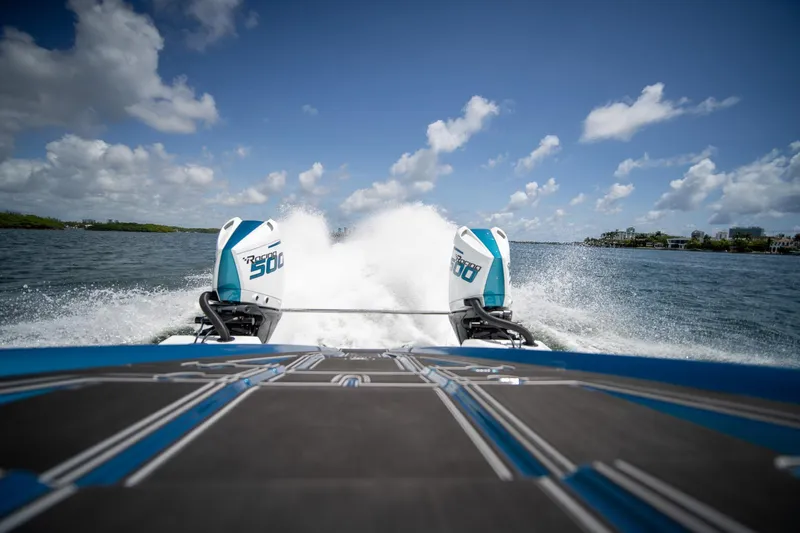  Yacht Photos Pics 2024 MTI 440X boat speeding on water, twin engines, clear blue sky.