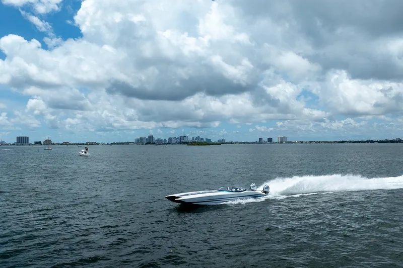  Yacht Photos Pics 2024 MTI 440X speedboat cruising on open water under a cloudy sky.