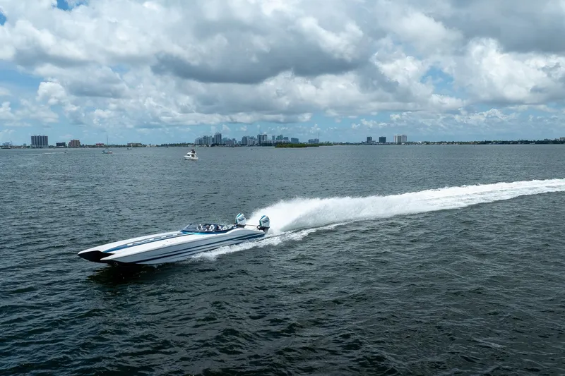  Yacht Photos Pics 2024 MTI 440X speedboat cruising on open water under cloudy sky.