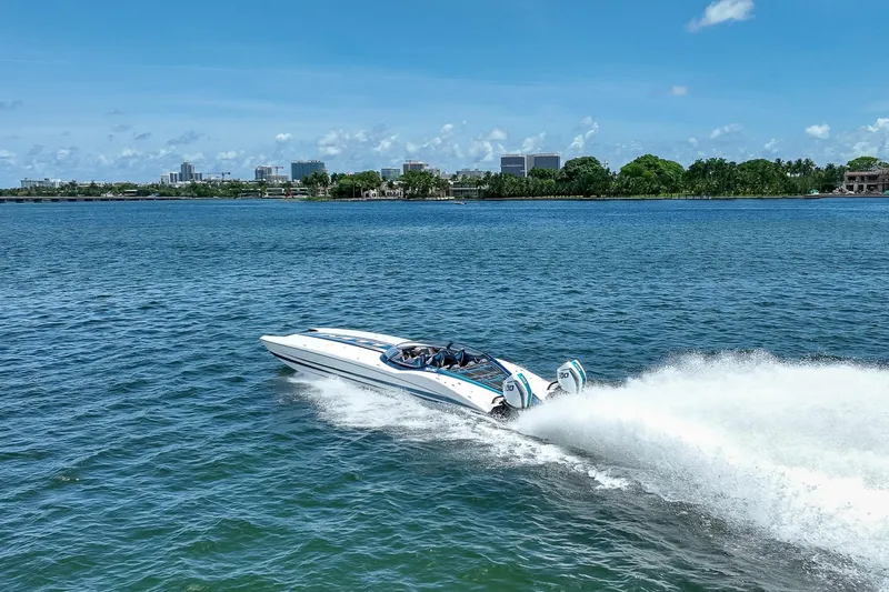  Yacht Photos Pics 2024 MTI 440X speedboat cruising on a sunny day, creating a wake in the water.
