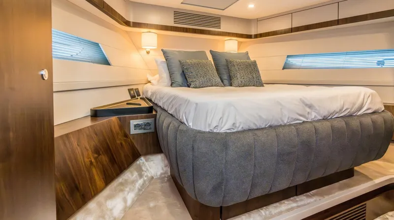  Yacht Photos Pics Luxurious bedroom interior of 2026 Fairline Phantom 65 yacht with modern design and cozy bedding.