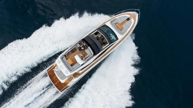 Yacht Photos Pics 2026 Fairline Phantom 65 yacht cruising on open water, aerial view.