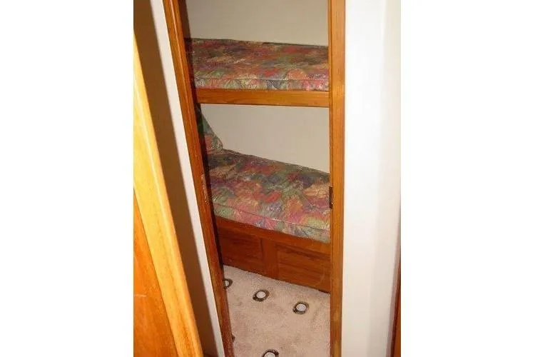  Yacht Photos Pics Bunk beds in 1996 Viking 50 Convertible yacht interior, featuring colorful bedding.