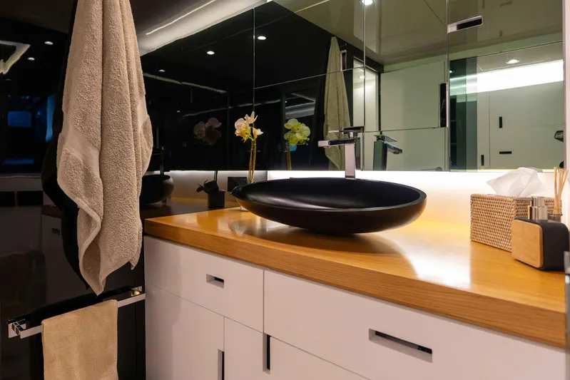 Matariki Yacht Photos Pics Modern bathroom with black vessel sink, wooden countertop, and elegant lighting. Maori 78, 2014.