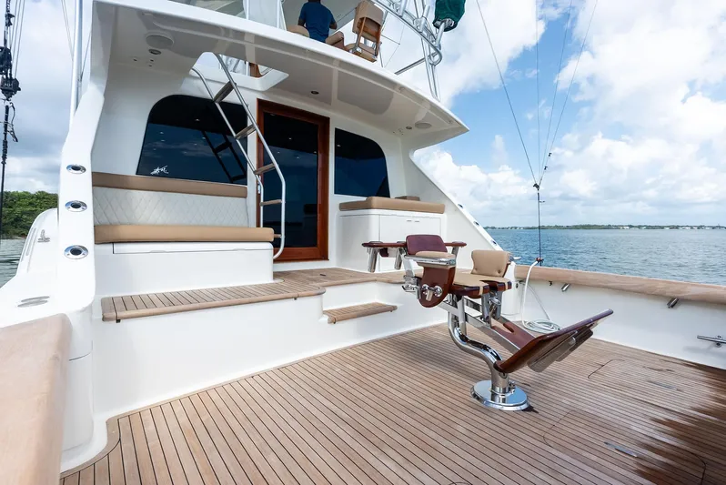 Typhoon I Yacht Photos Pics 2008 Tribute Sportfish yacht deck with fishing chair, wooden flooring, and ocean view.