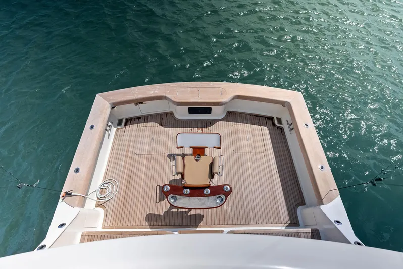 Typhoon I Yacht Photos Pics 2008 Tribute Sportfish boat deck with fishing chair, surrounded by calm blue water.