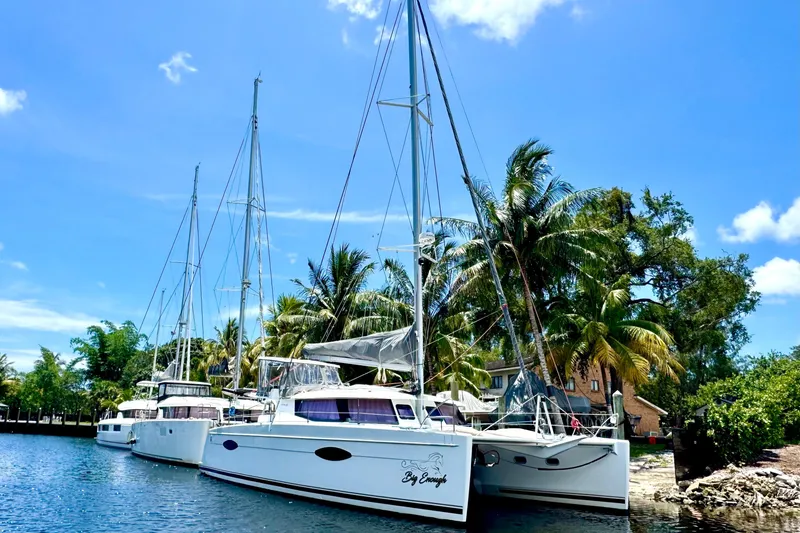 Big Enough Yacht Photos Pics 2014 Fountaine Pajot Helia 44 catamaran docked by palm trees under blue sky.
