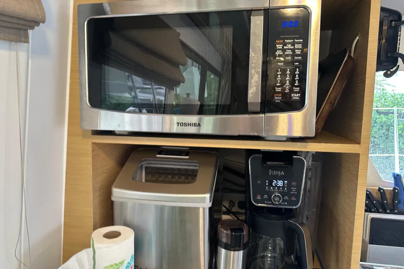 Big Enough Yacht Photos Pics Kitchen appliances on Fountaine Pajot Helia 44 yacht, featuring a microwave, coffee maker, and paper towels.