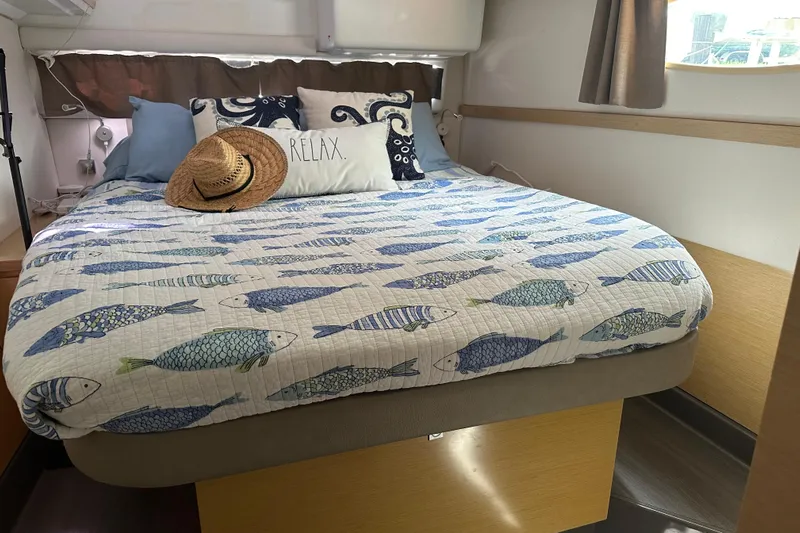 Big Enough Yacht Photos Pics Cozy bedroom in 2014 Fountaine Pajot Helia 44 with fish-themed bedding and straw hat.