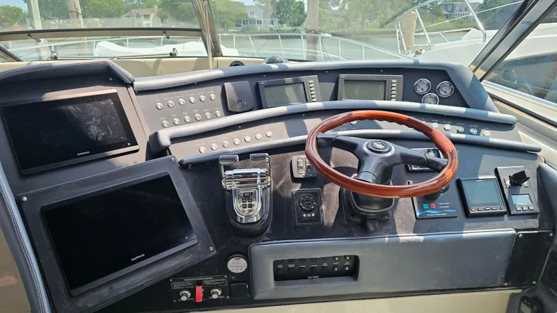  Yacht Photos Pics 1999 Sea Ray 500 Sundancer helm with wood steering wheel and modern navigation displays.