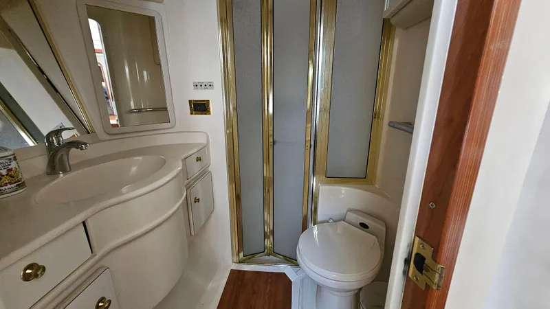  Yacht Photos Pics Luxurious bathroom in 1999 Sea Ray 500 Sundancer yacht with shower, sink, and toilet.