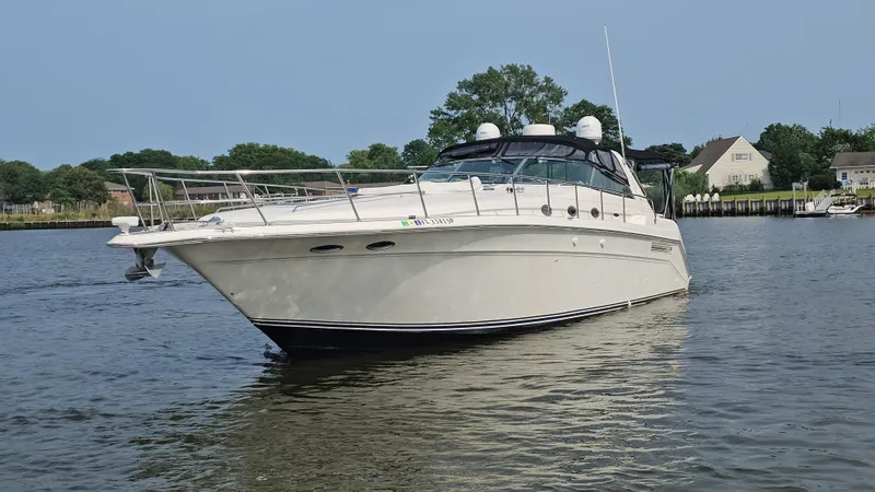  Yacht Photos Pics 1999 Sea Ray 500 Sundancer yacht on calm water near residential area.