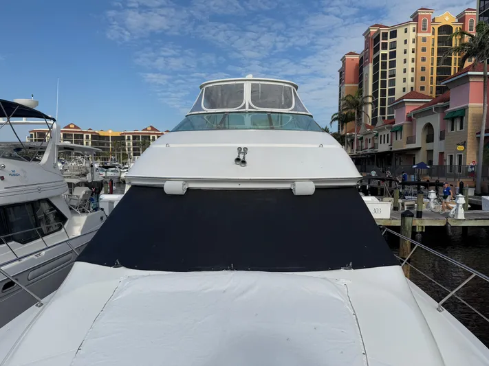  Yacht Photos Pics 2002 Carver 530 Voyager Pilothouse yacht docked at marina with buildings in background.