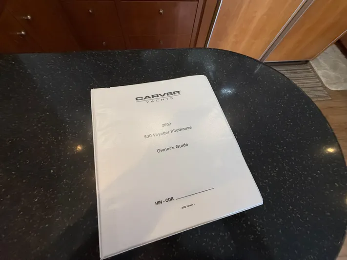 Yacht Photos Pics Owner's guide for 2002 Carver 530 Voyager Pilothouse on a dark countertop.