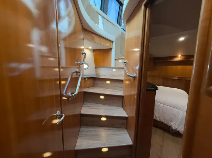 Yacht Photos Pics Luxurious interior of 2002 Carver 530 Voyager Pilothouse with wooden stairs and cozy bedroom.