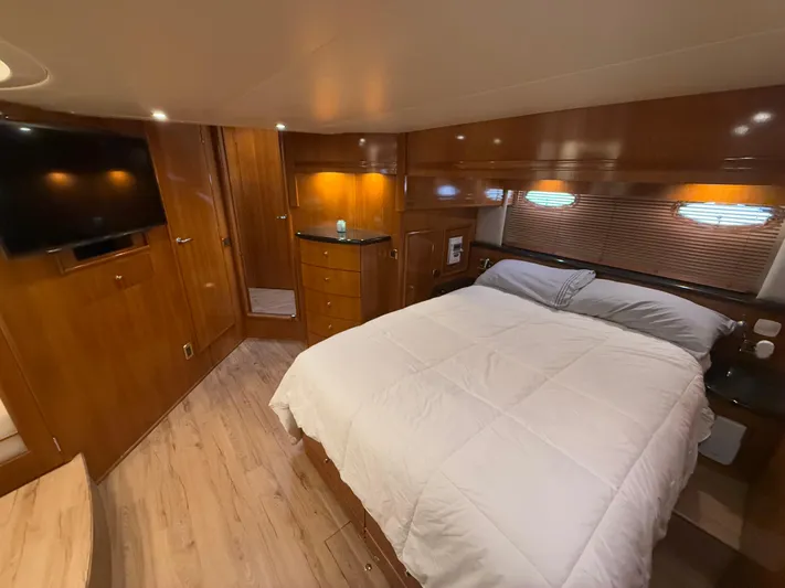  Yacht Photos Pics Luxurious bedroom in 2002 Carver 530 Voyager Pilothouse yacht with wood accents and modern amenities.