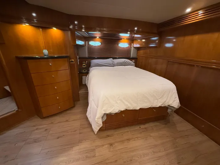 Yacht Photos Pics Luxurious bedroom in 2002 Carver 530 Voyager Pilothouse yacht with wood paneling and cozy lighting.