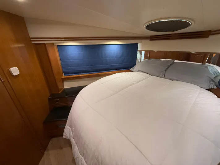  Yacht Photos Pics 2002 Carver 530 Voyager Pilothouse bedroom with cozy bed and wooden interior.