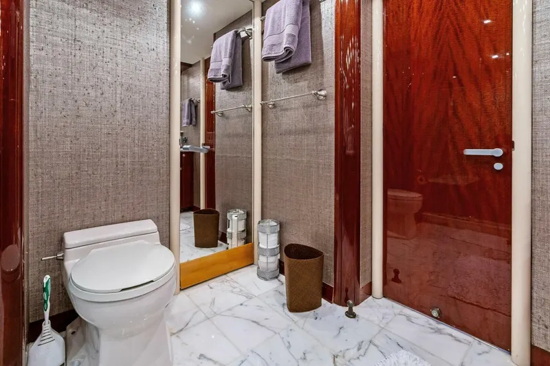 Summerwind Yacht Photos Pics Luxurious bathroom in 2005 Lazarra 80 yacht with marble flooring and elegant wood accents.