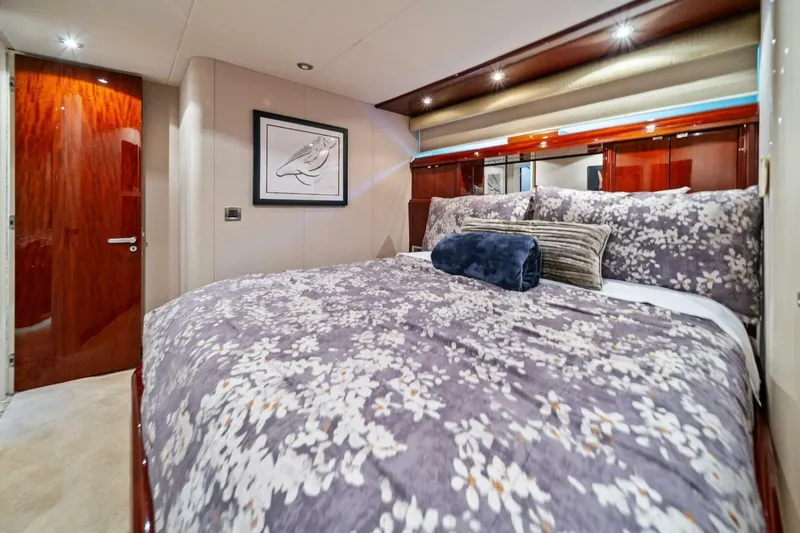 Summerwind Yacht Photos Pics Luxurious bedroom interior of 2005 Lazarra 80 yacht with floral bedding and elegant wood finishes.