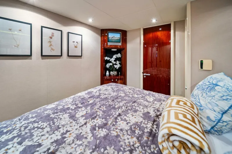 Summerwind Yacht Photos Pics Luxurious bedroom interior on 2005 Lazarra 80 yacht with floral decor and elegant wood finishes.