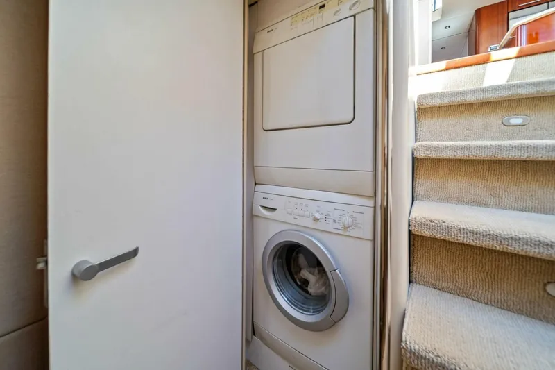 Summerwind Yacht Photos Pics Stacked washer and dryer in 2005 Lazarra 80 yacht interior near carpeted stairs.