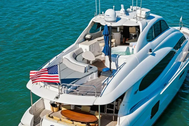Summerwind Yacht Photos Pics Luxury 2005 Lazarra 80 yacht with American flag, cruising on blue waters.