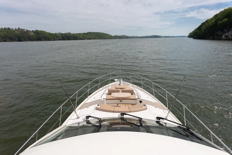 Janie Yacht Photos Pics 2018 Sea Ray L650 Fly yacht cruising on a serene lake with lush green shoreline.