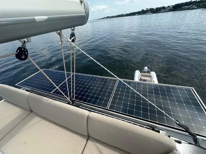 Moon Doggie Yacht Photos Pics 2022 Fountaine Pajot Tanna 47 yacht with solar panels and a tender on calm water.