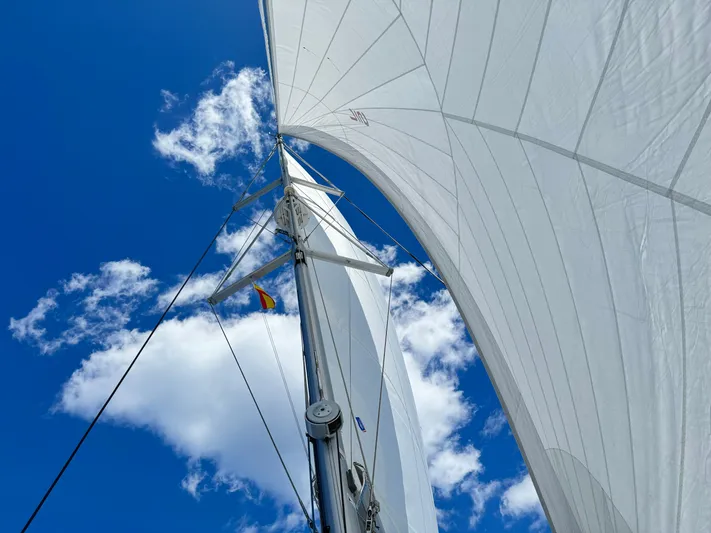 Moon Doggie Yacht Photos Pics Sails of 2022 Fountaine Pajot Tanna 47 against a bright blue sky.