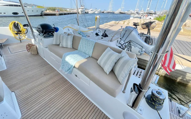 Moon Doggie Yacht Photos Pics Luxurious 2022 Fountaine Pajot Tanna 47 yacht deck with comfortable seating and scenic marina view.