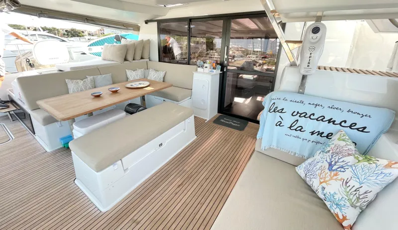 Moon Doggie Yacht Photos Pics Luxurious 2022 Fountaine Pajot Tanna 47 yacht interior with elegant seating and dining area.