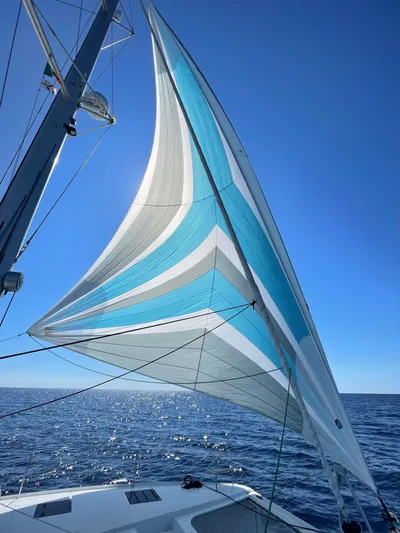 Moon Doggie Yacht Photos Pics Sailing on a 2022 Fountaine Pajot Tanna 47 with vibrant blue and white sails.