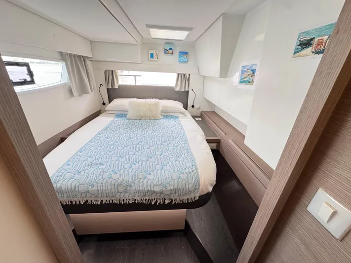 Moon Doggie Yacht Photos Pics Luxurious cabin interior of 2022 Fountaine Pajot Tanna 47 yacht, featuring a cozy bed.