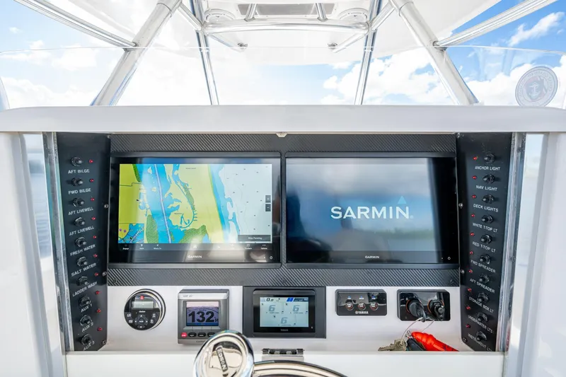 Checkered Flag Yacht Photos Pics Control panel of a 2011 Bahama 37 boat with navigation screens and switches.