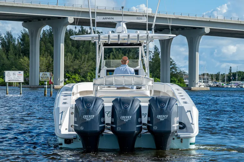 Checkered Flag Yacht Photos Pics 2011 Bahama 37 boat with triple Yamaha engines under a bridge on a sunny day.