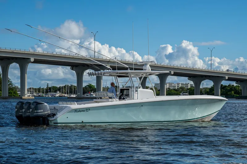 Checkered Flag Yacht Photos Pics 2011 Bahama 37 boat on water near bridge, clear sky background.