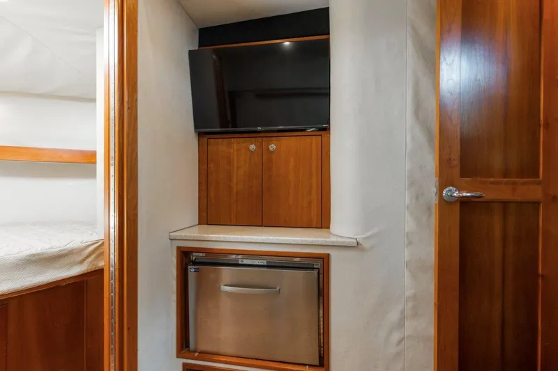 Tin Bender Yacht Photos Pics 2009 Albemarle 360 XF interior with TV, wooden cabinets, and mini fridge.
