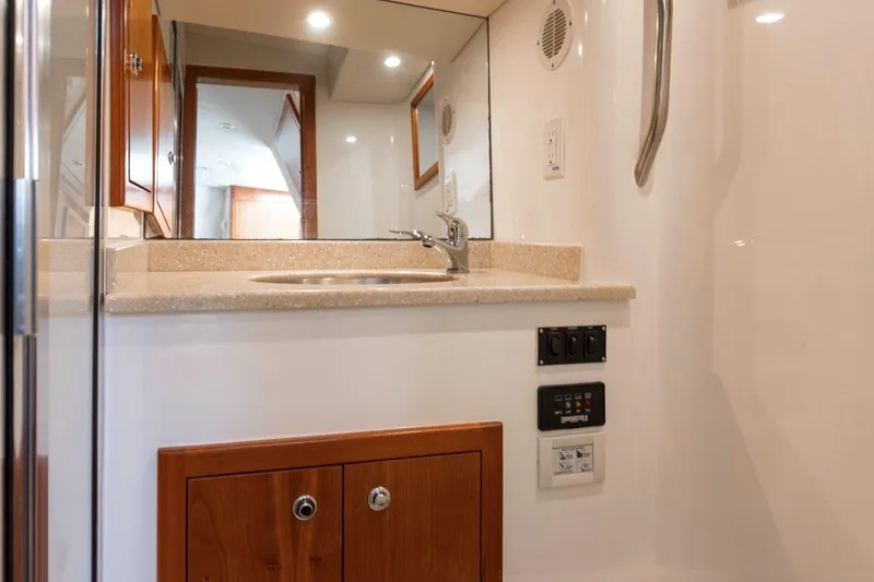 Tin Bender Yacht Photos Pics 2009 Albemarle 360 XF yacht bathroom with sink, mirror, and wooden cabinetry.