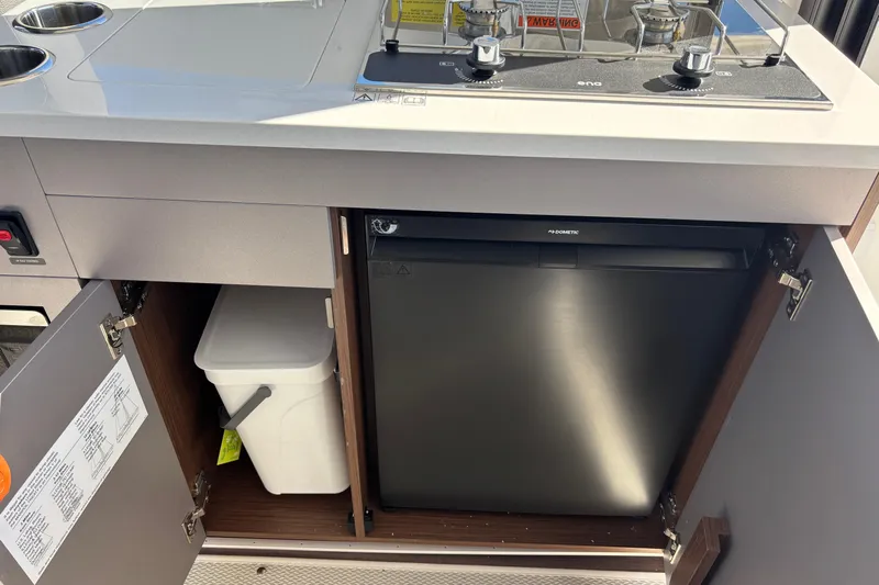  Yacht Photos Pics 2026 Beneteau Antares 9 V2 kitchen with stove, fridge, and storage cabinets.