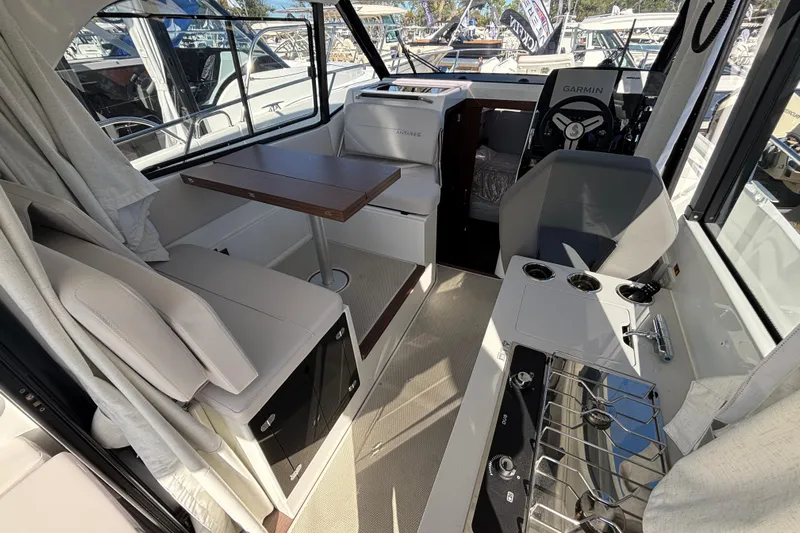  Yacht Photos Pics Interior of 2026 Beneteau Antares 9 V2 boat, featuring seating, table, and helm.
