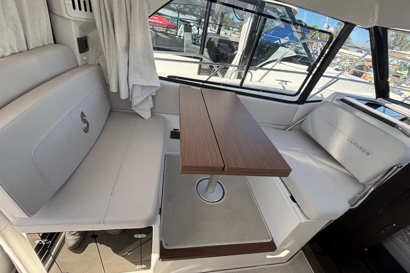  Yacht Photos Pics Interior of 2026 Beneteau Antares 9 V2, featuring elegant seating and wooden table.