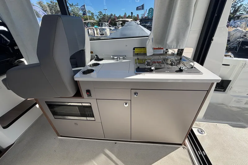  Yacht Photos Pics Interior of 2026 Beneteau Antares 9 V2 featuring a compact kitchen with stove and microwave.