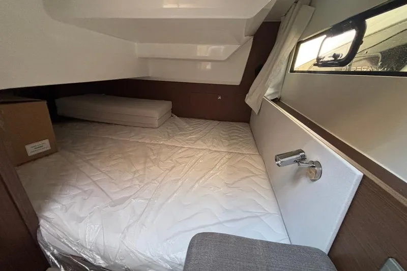  Yacht Photos Pics Interior cabin of 2026 Beneteau Antares 9 V2, featuring a cozy bed and window.