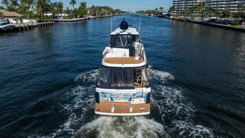 Just A Dream Yacht Photos Pics 2005 Carver 56 Voyager yacht cruising on a scenic waterway with palm trees.