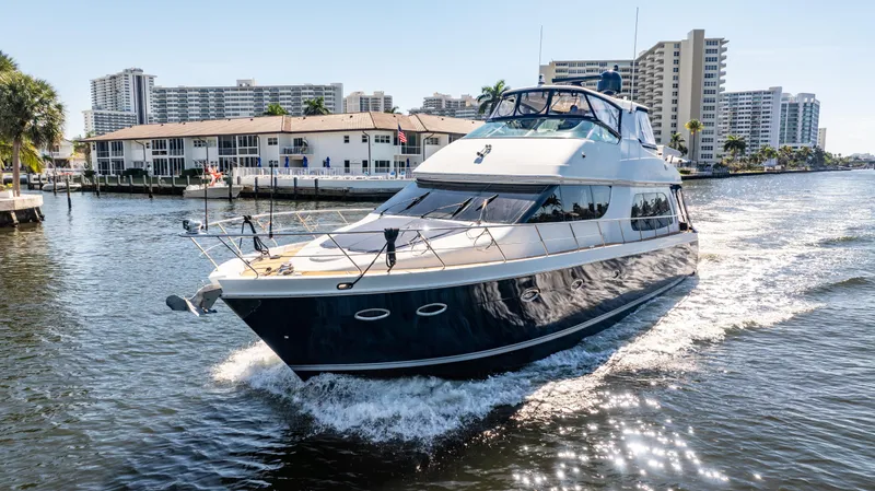 Just A Dream Yacht Photos Pics 2005 Carver 56 Voyager yacht cruising in a sunny waterfront cityscape.