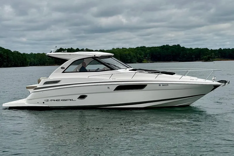  Yacht Photos Pics 2018 Regal 35 Sport Coupe cruising on a serene lake under cloudy skies.